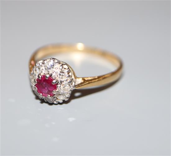 A mid 20th century yellow metal (stamped 18ct and Plat), ruby and diamond cluster ring, size L/M, gross 2.4 grams.